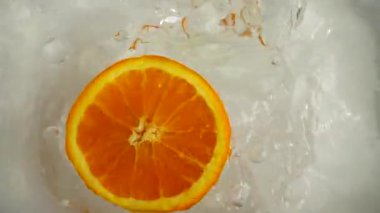 Portakallar suya düşüyor. Yavaş çekim.