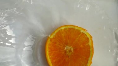 Portakallar suya düşüyor. Yavaş çekim.