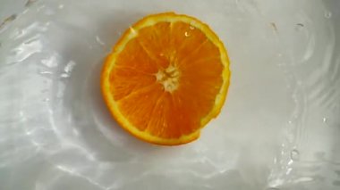 Portakallar suya düşüyor. Yavaş çekim.