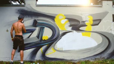 Sanatçı çitlere grafiti çiziyor. Çitin üzerindeki graffiti.