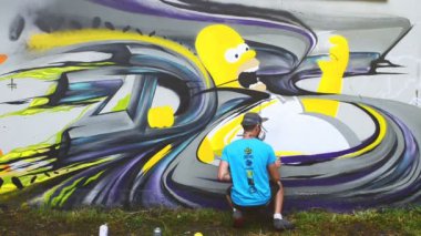 Sanatçı çitlere grafiti çiziyor. Çitin üzerindeki graffiti.