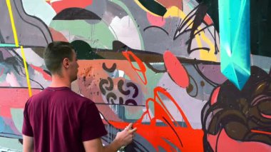 Sanatçı çitlere grafiti çiziyor. Çitin üzerindeki graffiti.