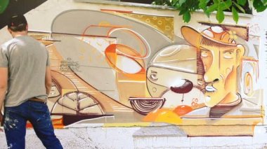 Sanatçı çitlere grafiti çiziyor. Çitin üzerindeki graffiti.