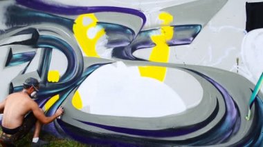 Sanatçı çitlere grafiti çiziyor. Çitin üzerindeki graffiti.