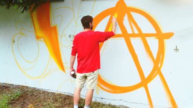 Sanatçı çitlere grafiti çiziyor. Soyut çizim.