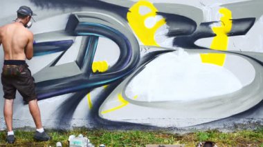 Sanatçı çitlere grafiti çiziyor. Çitin üzerindeki graffiti.