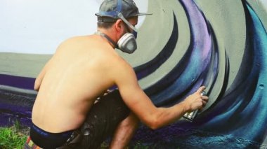 Sanatçı çitlere grafiti çiziyor. Çitin üzerindeki graffiti.