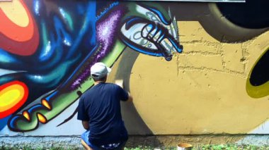 Sanatçı çitlere grafiti çiziyor. Soyut çizim.