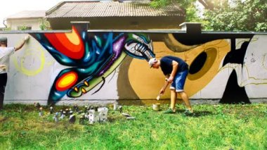 Sanatçılar çitlere grafiti çiziyor. Soyut çizim.