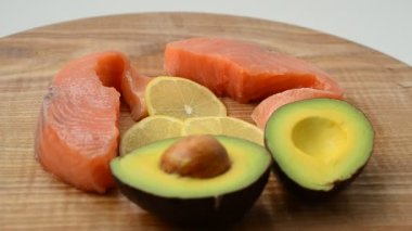 Mutfak tahtasında tuzlu somon, avokado ve limon. Lezzetli hayat, birleşik ürünler..