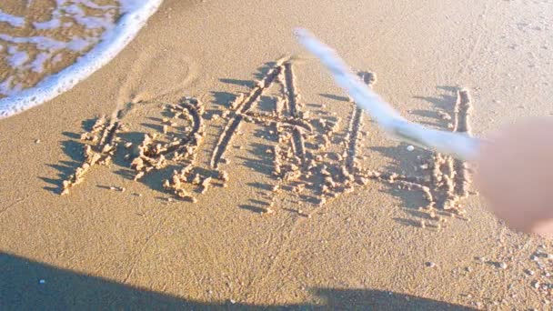 砂の上にバリの碑文 銘文は棒で書かれている — ストック動画