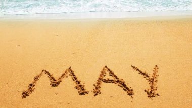 Kumsaldaki ayın isminin yazılı olduğu bir yazı. Sahilde çekim yapmak..