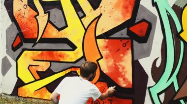 Sanatçı çitlere grafiti çiziyor. Çitin üzerindeki graffiti.