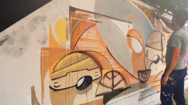 Sanatçı çitlere grafiti çiziyor. Çitin üzerindeki graffiti.