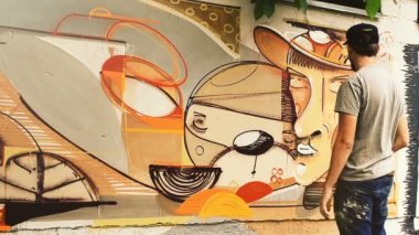 Sanatçı çitlere grafiti çiziyor. Çitin üzerindeki graffiti.