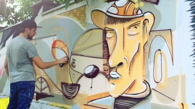 Sanatçı çitlere grafiti çiziyor. Çitin üzerindeki graffiti.