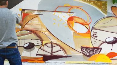 Sanatçı çitlere grafiti çiziyor. Çitin üzerindeki graffiti.