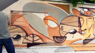 Sanatçı çitlere grafiti çiziyor. Çitin üzerindeki graffiti.
