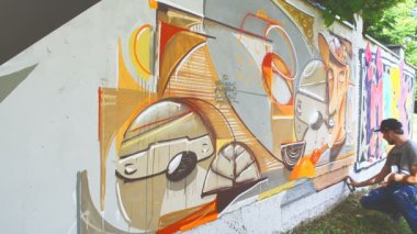 Sanatçı çitlere grafiti çiziyor. Çitin üzerindeki graffiti.