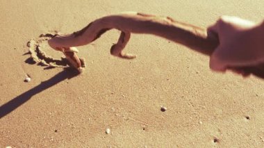 Kum üzerinde sos kelimesi. Kumsal. Sahilde çekim yapmak..