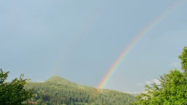 Dağın üzerinden gökkuşağı. Zaman ayarlı. Gökkuşağı vuruşu.