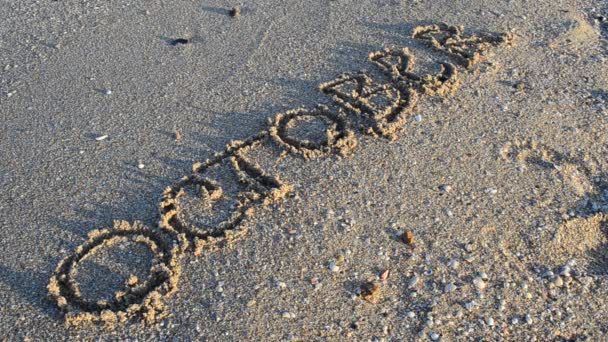 Inschrijving Oktober Zand Inscriptie Wordt Weggespoeld Door Een Zeegolf Schieten — Stockvideo