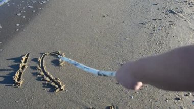 Kumsaldaki aşk işareti. Sahilde çekim yapmak..