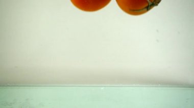 Domatesler suya düşer. Yavaş çekim.