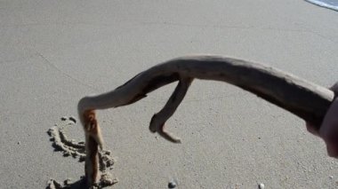 Güneşi kumsala kazıyın. Sahilde çekim yapmak..