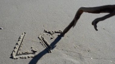 Kumsaldaki aşk işareti. Sahilde çekim yapmak..