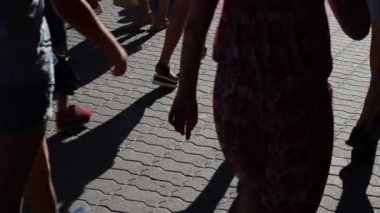 Işık ve gölge, batan güneşin ışınlarındaki insanların yansıması. Bir grup insanın hareketi.