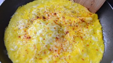 Bir omlet kızartırız. Tavadaki yumurtadan omlet..
