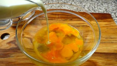 Yumurta sarısına süt enjekte etmek. Omlet hazırlığı için. Yavaş çekim.