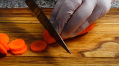 Aşçı kesme tahtasına havuç kesiyor..