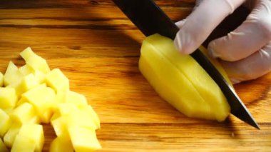 Aşçı patatesleri kesme tahtasıyla keser..