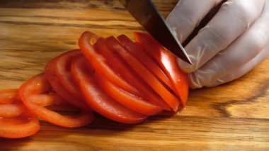 Aşçı domatesleri kesme tahtasıyla keser..