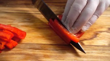 Tahta kesme tahtasında tatlı biber dilimliyorum..