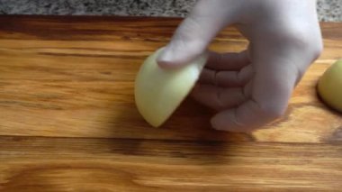 Ahşap tahtanın soğanını bıçakla kesen şefin elleri. Yemek hazırlığı. Sağlıklı beslenme ve yaşam tarzı.