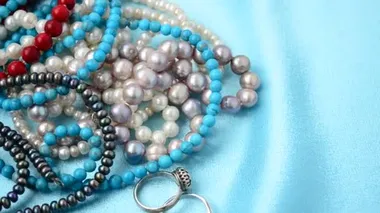 İncilerden boncuklar. Mavi ipek üzerinde çekim