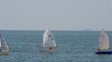 Tatil sezonunun onuruna yelkenli yarışı. Berdyansk şehri, Ukrayna. Denizde yatlar.