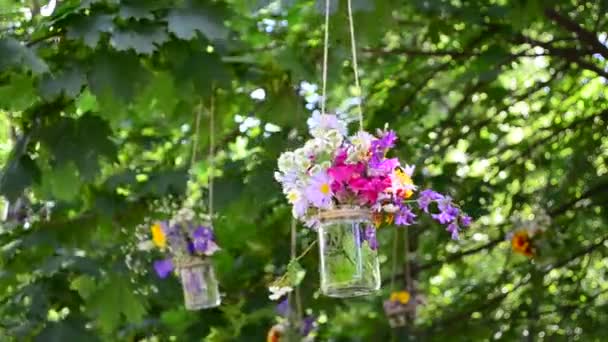 玻璃瓶里的花 安装在公园 篮子和树枝上的花 — 图库视频影像