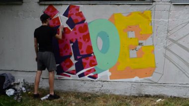 Grafiti ve çit oluşturma süreci. Sanatçı graffiti çiziyor.
