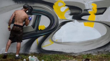 Grafiti ve çit oluşturma süreci. Sanatçı graffiti çiziyor.