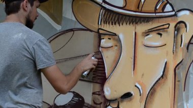 Ressam graffiti çiziyor, piposu olan kişinin resmi..