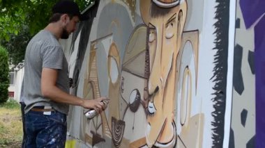 Ressam graffiti çiziyor, piposu olan kişinin resmi..