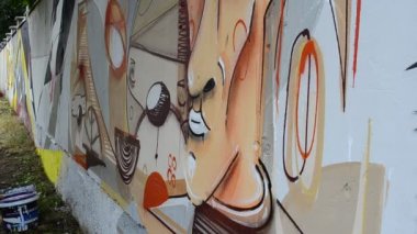 Ressam graffiti çiziyor, piposu olan kişinin resmi..