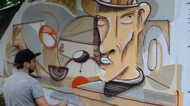 Ressam graffiti çiziyor, piposu olan kişinin resmi..