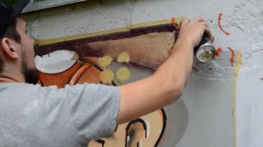 Ressam graffiti çiziyor, piposu olan kişinin resmi..