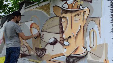 Ressam graffiti çiziyor, piposu olan kişinin resmi..