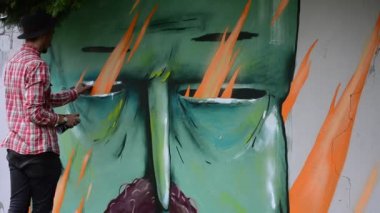 Ressam çitlere grafiti çiziyor, Kozak çiziyor..